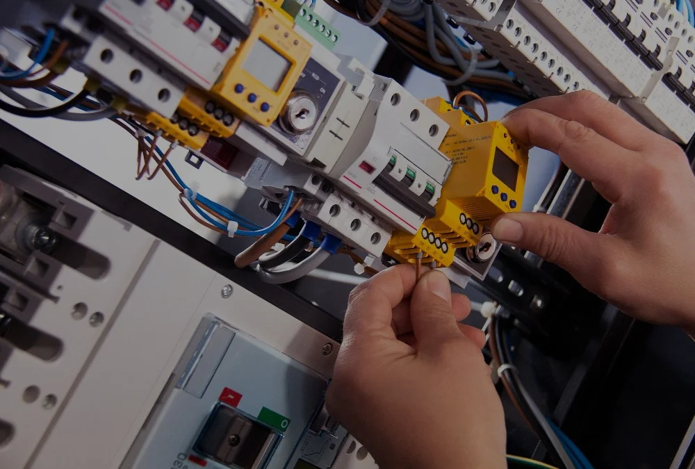 Elektriker arbetar med elinstallation i kopplingsskåp
