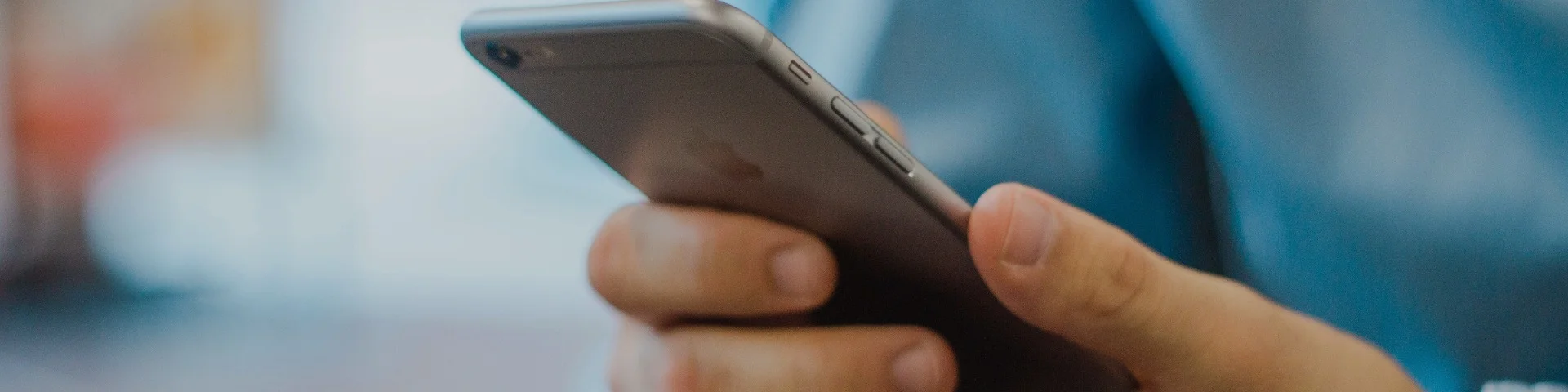 Person håller i telefon – kontakta Mer el