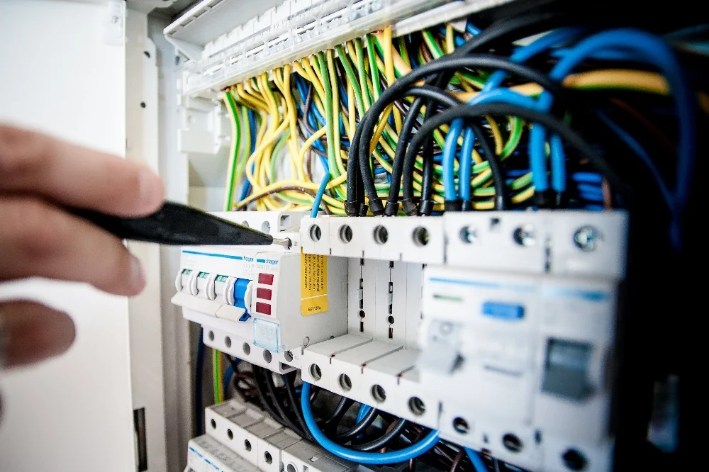 Elektriker vid elcentral med kablar